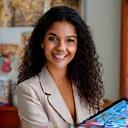 Professional headshot of Aisha Khan, a smiling comic artist with a dynamic art style, possibly at her drawing tablet.